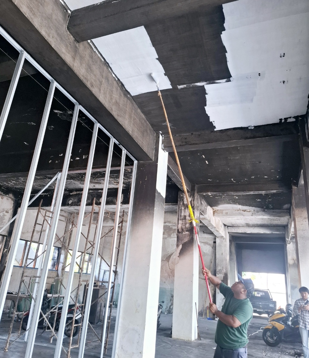 Pekerja sedang mengecat tempat parkir mobil yang akan diubah menjadi ruang rapat anggota dewan.