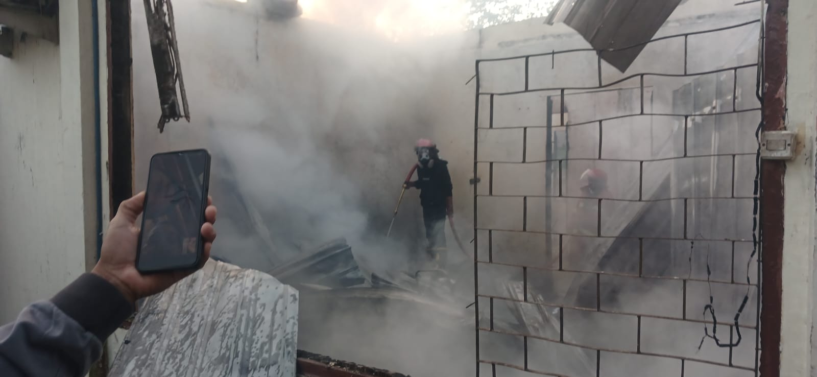 Petugas Dinas Pemadam Kebakaran dan Penyelamatan Kota Bima sedang memadamkan sisa api di kantor Inspektorat Kabupaten Bima, Kamis (7/8).