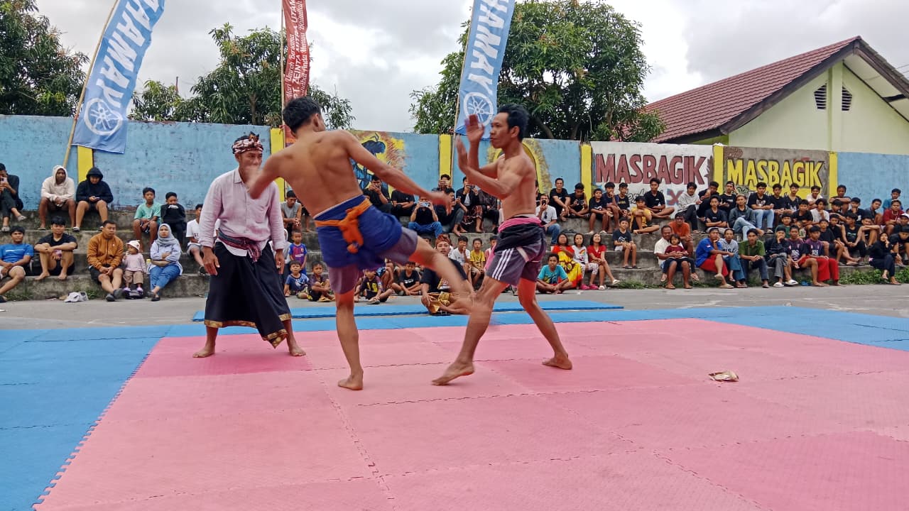 Dua orang petarung sedang adu kekuatan di atas arena Belanjakan yang digelar di lapangan umum Kecamatan Masbagik, sejak tanggal 16-22 September tingkat NTB, Minggu (21/9).