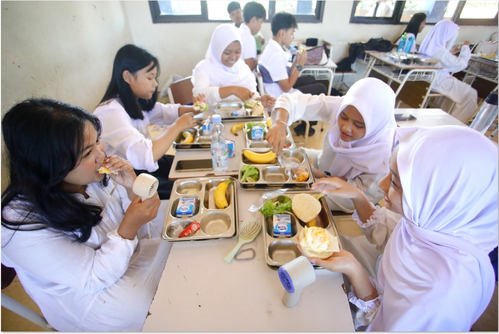 PENERIMA MANFAAT: Siswi kelas 10 SMAN 15 Surabaya sedang menyantap menu makan MBG, Jumat (19/9). DPR mengusulkan pengelolaan MBG diserahkan ke sekolah.