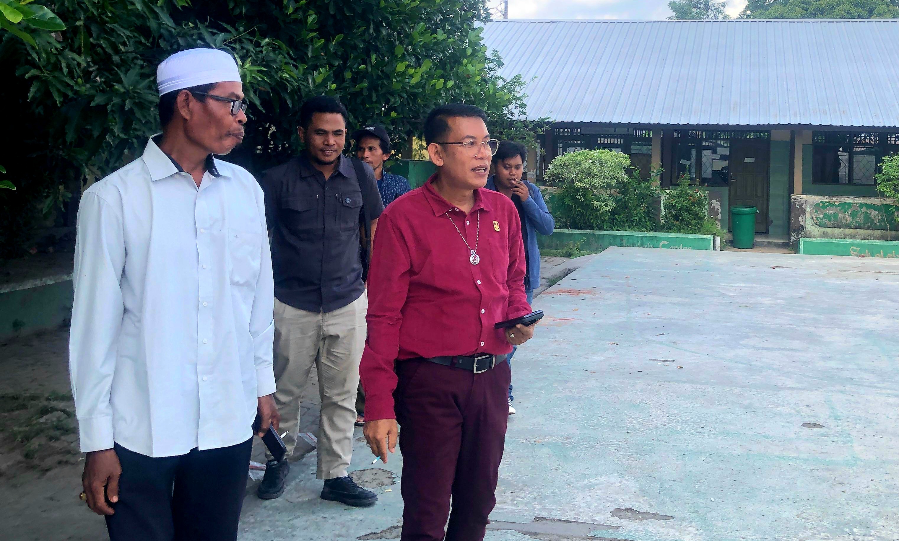 TURUN LANGSUNG: Anggota Komisi IV DPRD Lobar Dr. Syamsuriansyah (baju merah) saat mengecek kondisi SDN 3 Karang Bongkot yang disegel warga, Rabu (24/9).