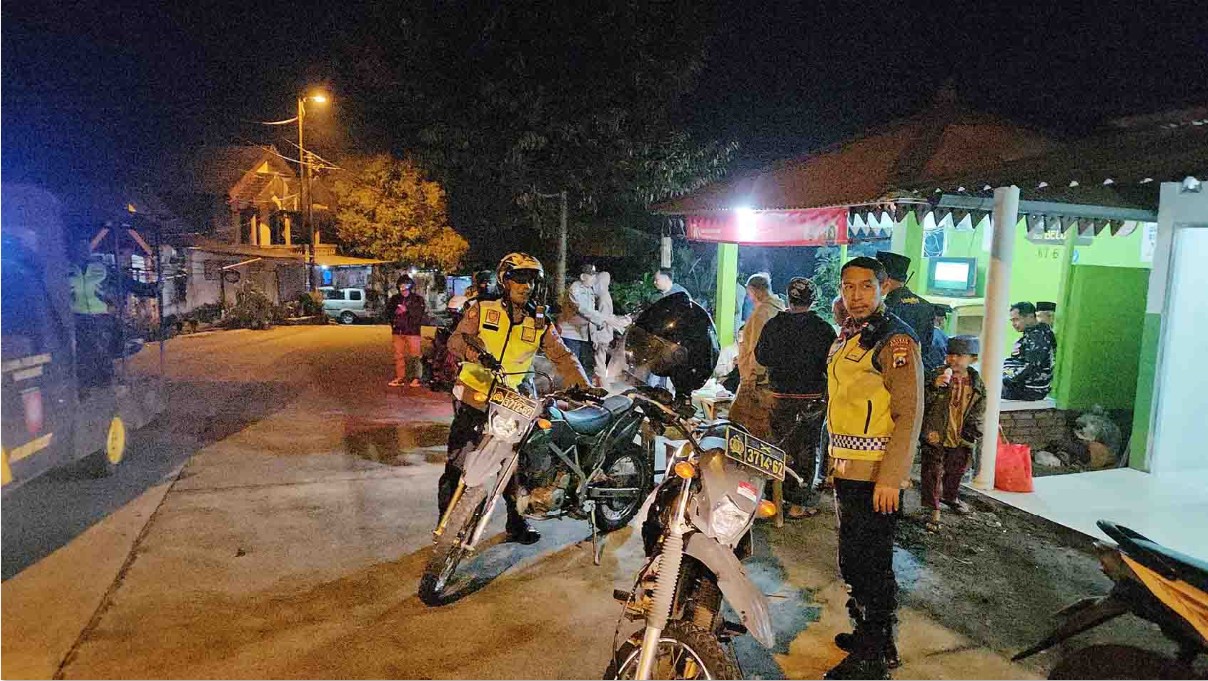 BAHU MEMBAHU: Petugas Polsek Pacet mendatangi warga yang sedang ronda malam di Desa Claket, Pacet, Kabupaten Mojokerto, Sabtu (20/9).