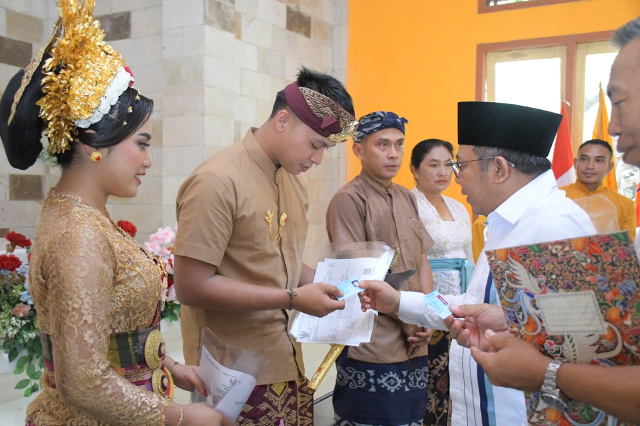 LANGSUNG DIANTAR: Bupati Najmul Akhyar menyerahkan akta nikah serta dokumen lainnya kepada salah satu pasangan pengantin.