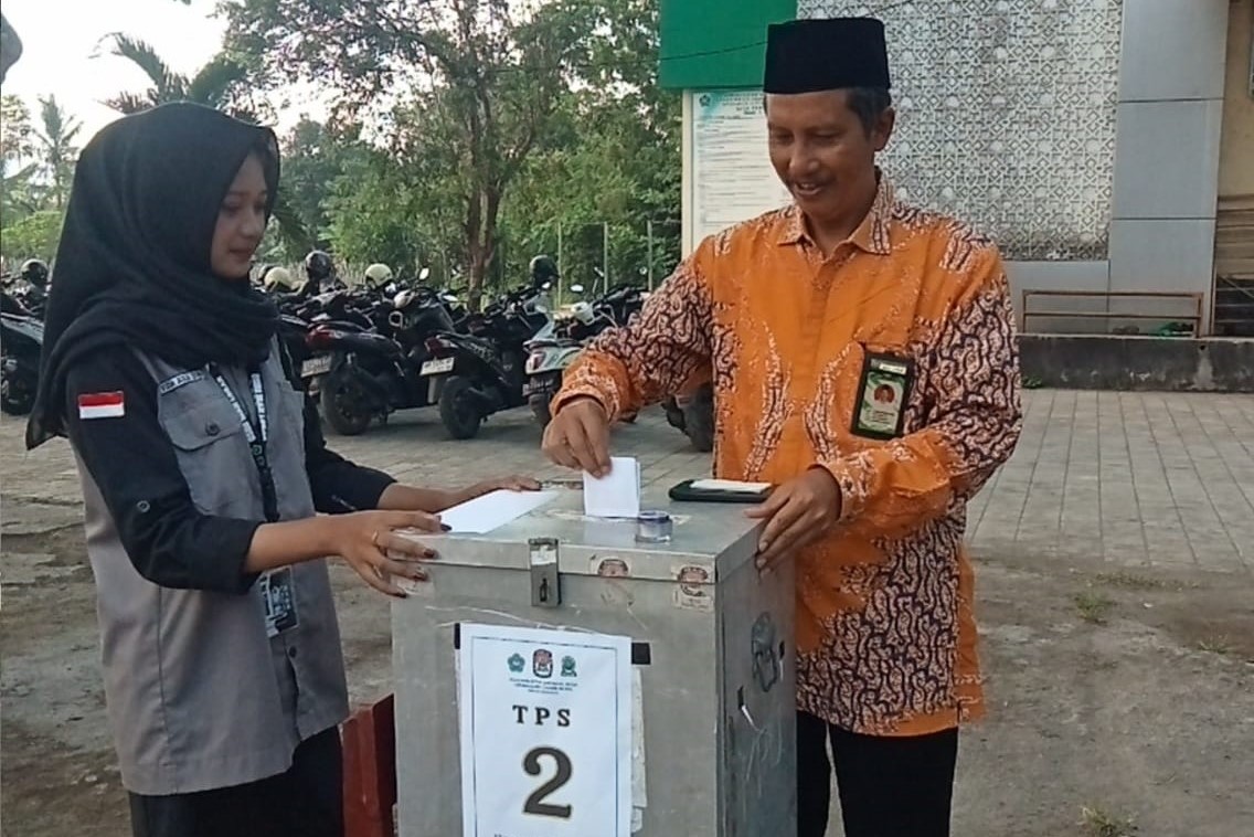 Kepala MAN Lombok Barat H Abdul Azis Faradi menggunakan hak suaranya pada Pemilu Orsima 2025-2026 yang digelar di halaman madrasah, Sabtu (27/9). Pemilu Orsima MAN Lombok Barat 2025 siswa belajar .
