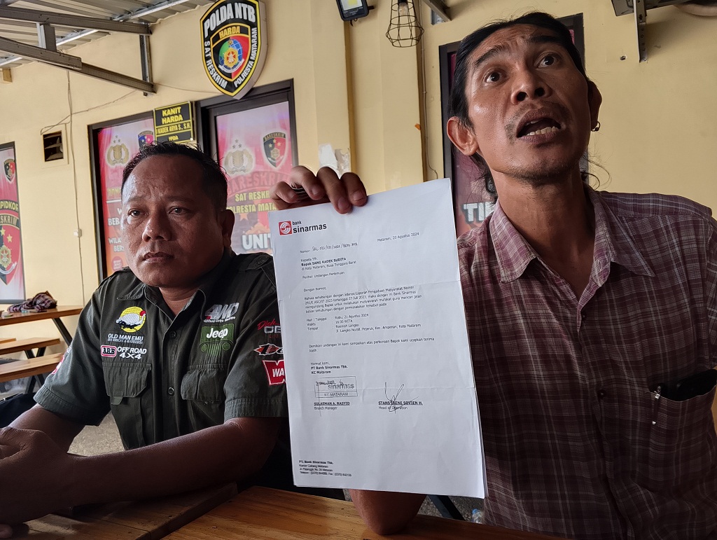 TUNJUKKAN BUKTI: Pengusaha Sang Kadek Sudita (kiri) didampingi kuasa hukumnya Jan Richard menunjukkan berkas dari Bank Sinarmas usai keluar dari ruang penyidik di Mapolresta Mataram
