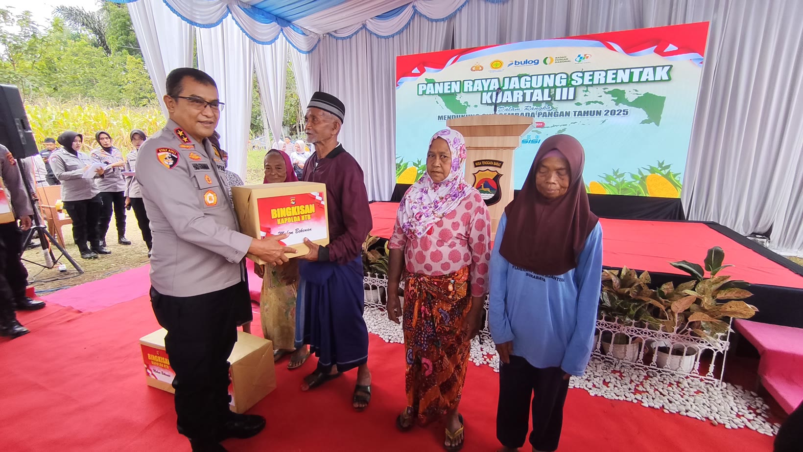 Kapolda NTB Irjen Pol Hadi Gunawan (kiri) berikan bingkisan pada lansia usai Panen Raya Jagung Serentak Kuartal III di Dusun Sapit, Selebung, Batukliang, Lombok Tengah, Sabtu (27/9).