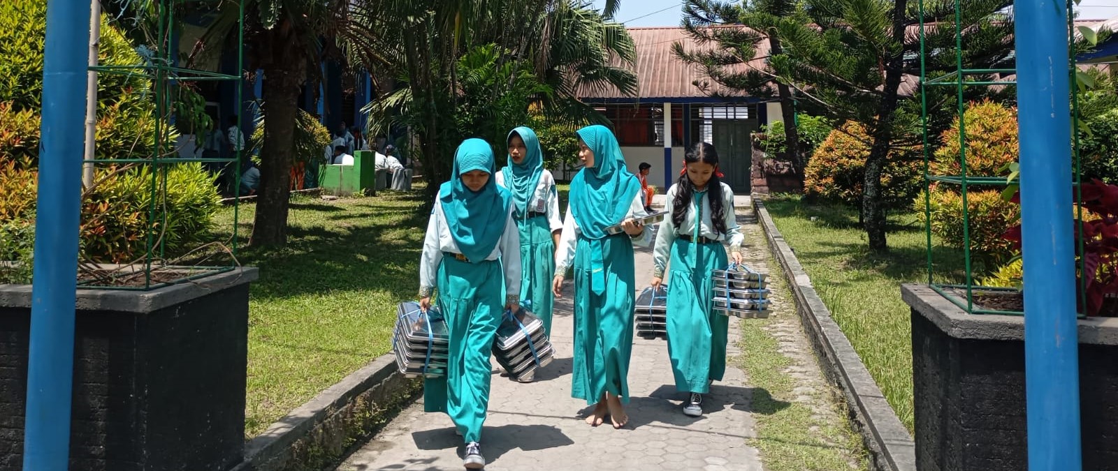 Empat siswa SMPN 7 Mataram mengambil paket MBG untuk dibawa ke ruang kelas. PGRI Kota Mataram soroti program MBG kurangi jam belajar.