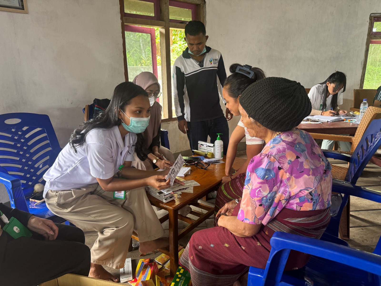 Petugas kesehatan menjelaskan penggunaan obata kepada salah seorang warga Desa Wewo dalam kegiatan pengobatan gratis