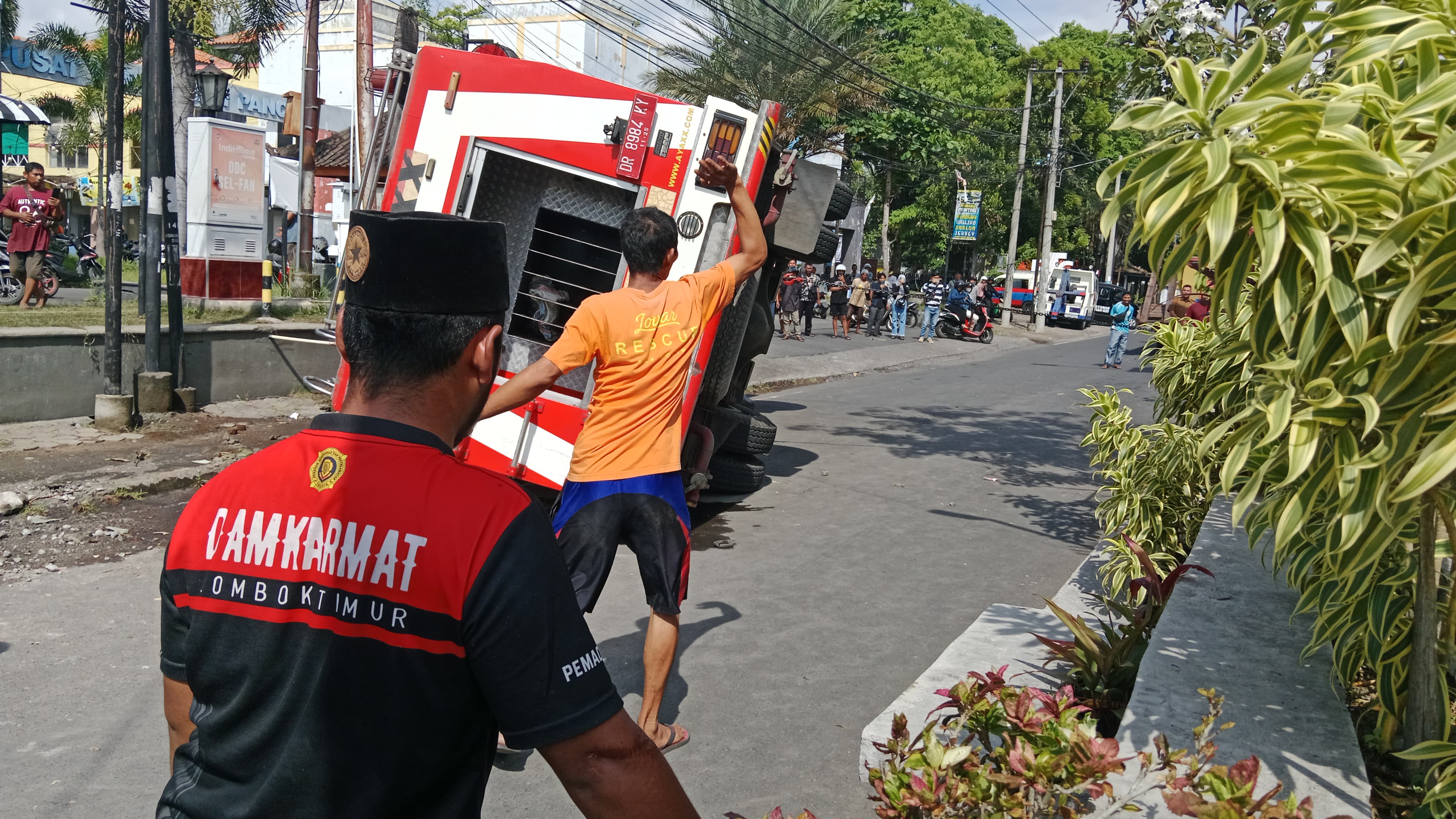 Petugas Damkarmat Lotim saat mengevakuasi mobil pemadam yang terbalik