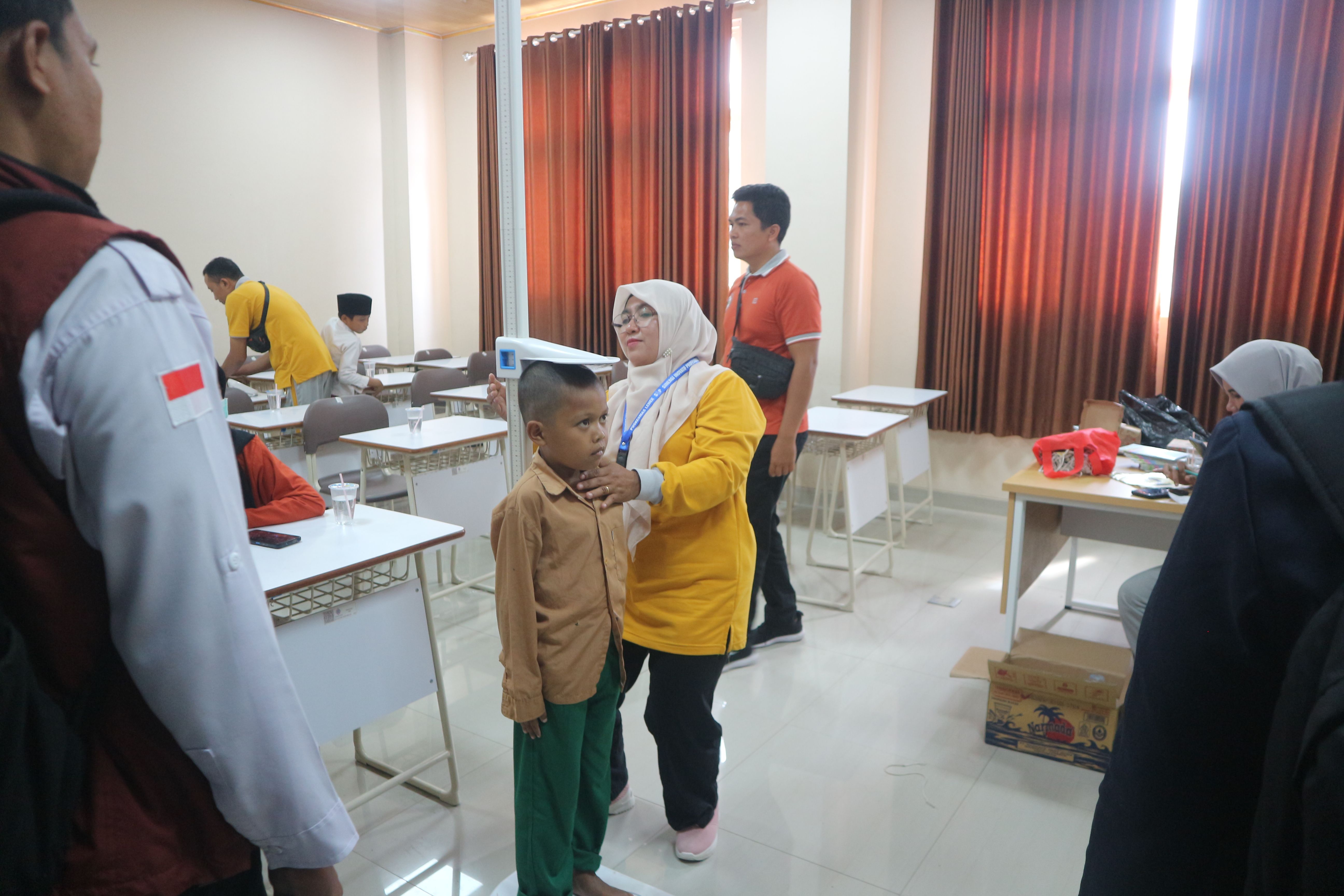 Petugas kesehatan sedang memeriksa kesehatan seorang murid Sekolah Rakyat Dasar Lombok Timur sebelum MPLS