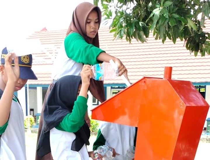 Siswa SMPN 17 Mataram memasukkan sampah plastik ke mesin pencacah di halaman sekolah setempat, belum lama ini. Sampah plastik diolah menjadi paving block.
