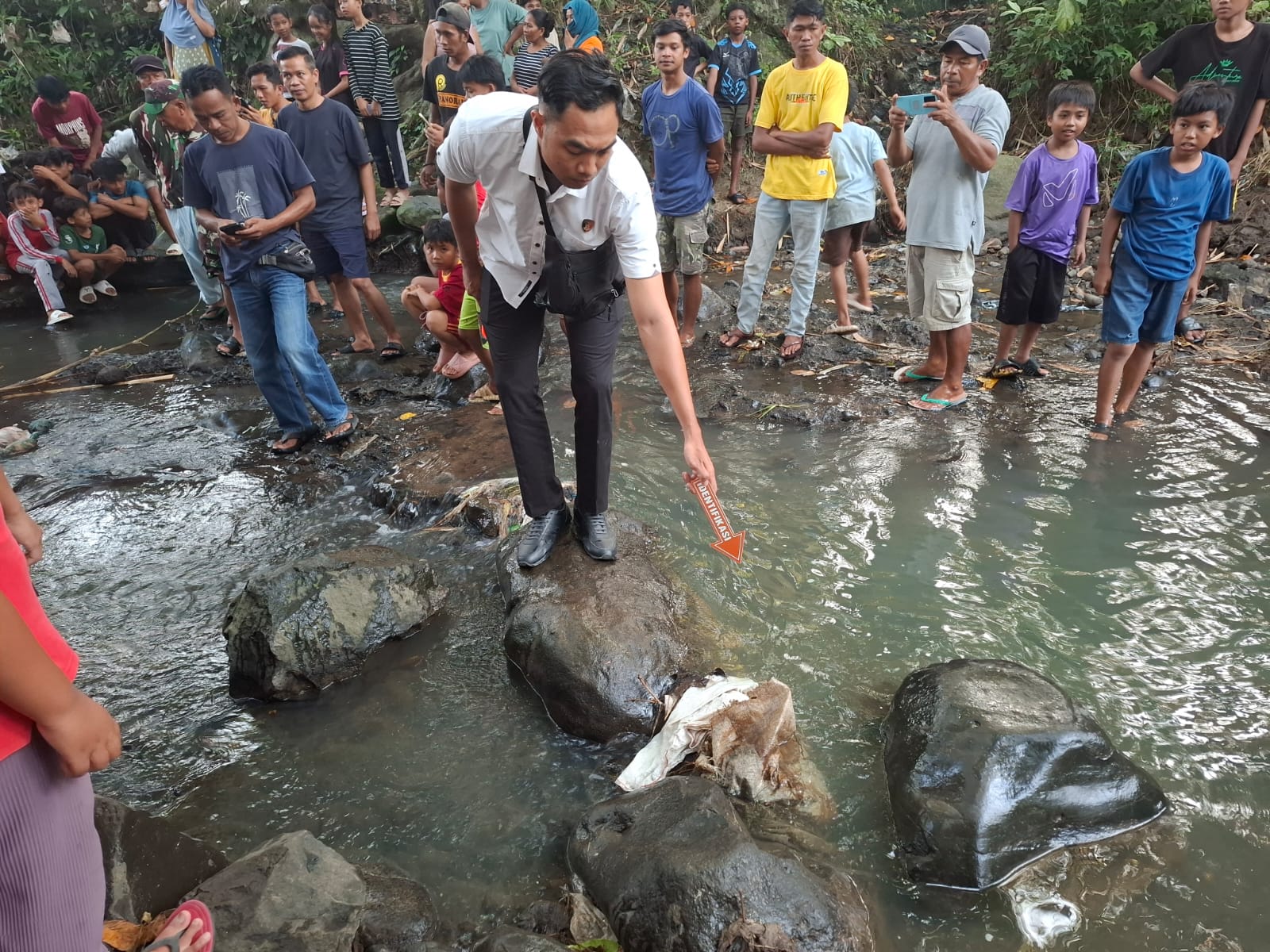 Seorang petugas serdang melakukan olah TKP di lokasi penemuan bayi di Sungai Desa Sukadana