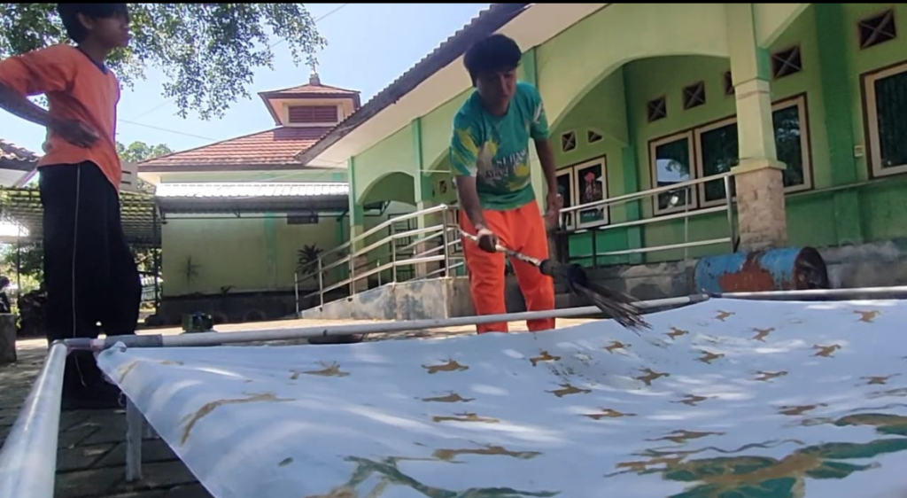 KREATIF: Seorang siswa SLBN 1 Kota Mataram yang sedang mewarnai batik dengan sapu lidi, beberapa waktu lalu.