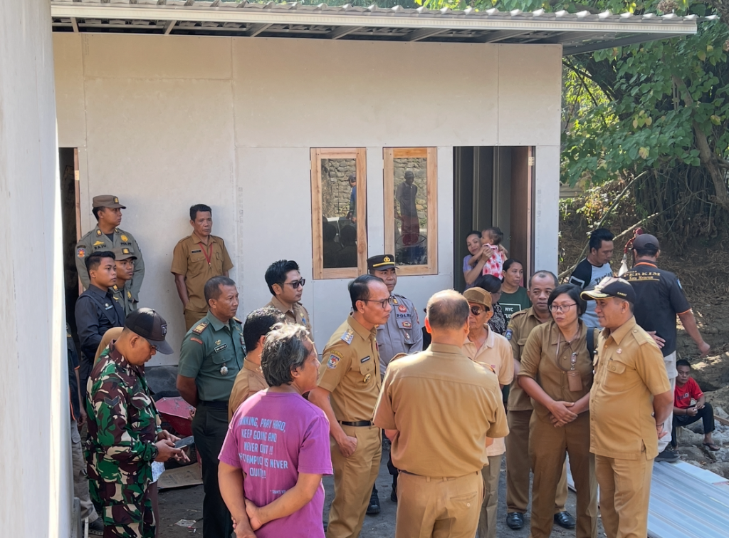 MENYIMAK: Seorang ibu sambil menggendong anak mendengar perbincangan Wali Kota Mohan Roliskana, Kepala Disperkim M Nazaruddin Fikri, dan pejabat lainnya untuk penataan Huntara Pamotan.