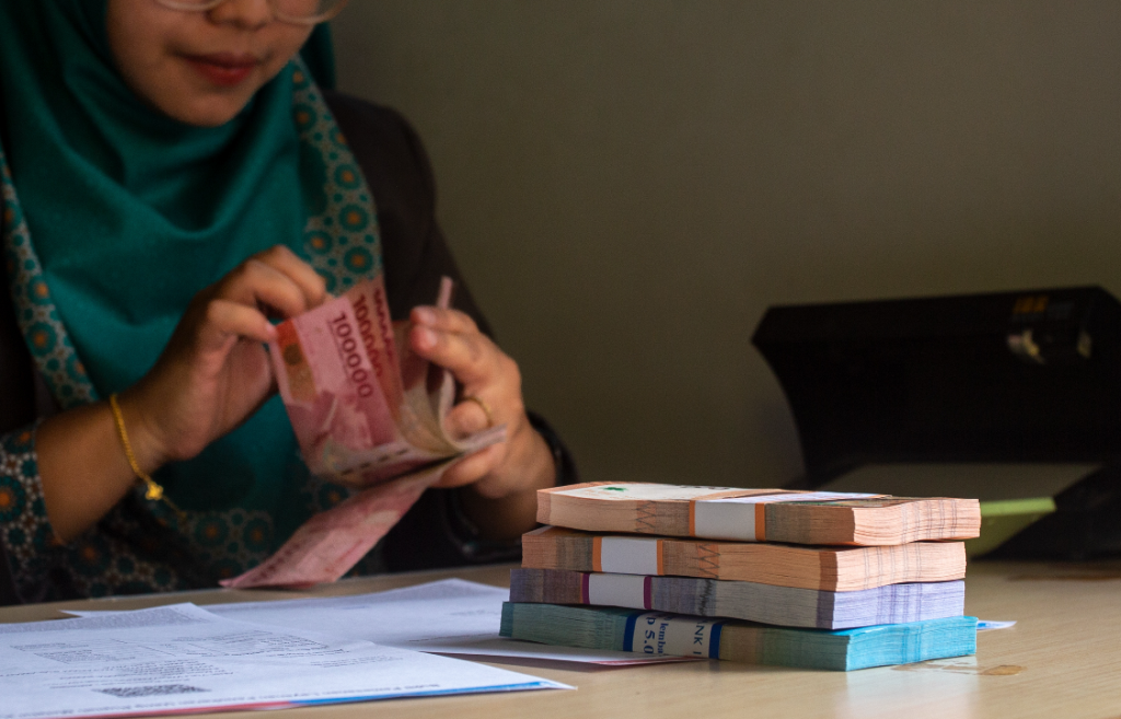 ILUSTRASI: Seorang teller bank tengah menghitung uang.