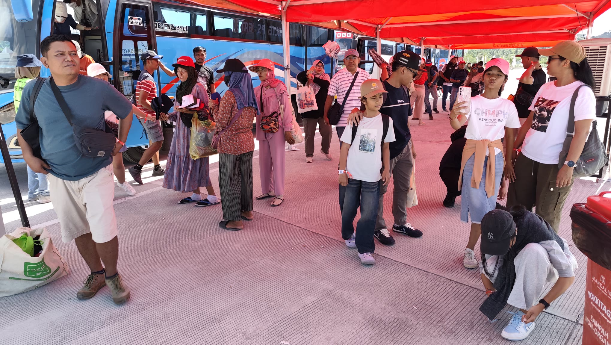 Ratusan penonton turun dari bus hendak menyaksikan balap MotoGP Mandalika 2025 di Sirkuit Mandalika, Minggu (5/10).