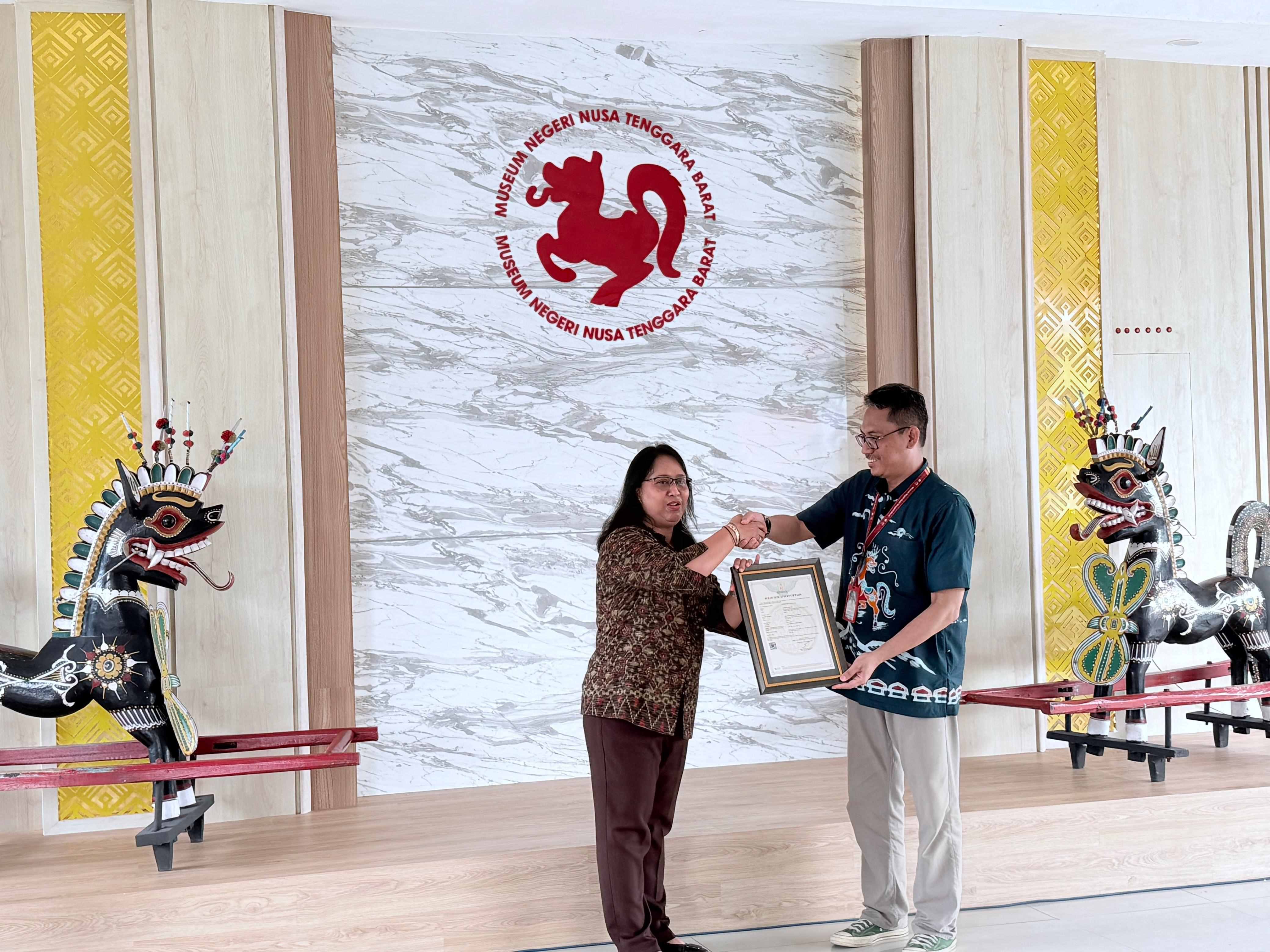 Kepala Museum Negeri NTB Ahmad Nuralam (kanan) saat menerima sertifikat hak cipta atas karya budaya, dari Kepala Kanwil Kemenkum NTB I Gusti Putu Milawati, Sabtu (11/10).