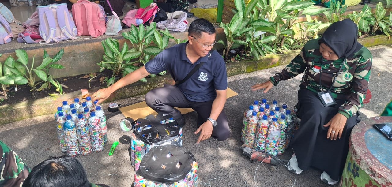 Pembina Bank Sampah Dinas Lingkungan Hidup (DLH) Kota Mataram I Made Wibisana Gunaksa bersama Kepala SDN 19 Cakranegara Sri Hartini mencoba kursi ramah lingkungan yang dibuat dari sampah plastik.