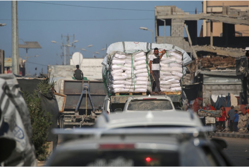 DUKUNG PALESTINA: Warga Palestina berjalan melewati bangunan hancur di Jalur Gaza Selasa (14/10). Indonesia tetap menolak pesenam Israel tampil di kejuaraan senam di Jakarta. SUZANNE PLUNKETT / AFP