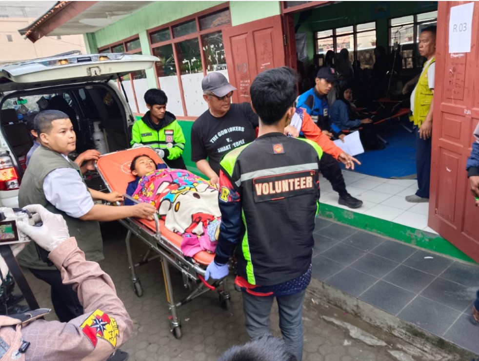 PENANGANAN MEDIS: Seorang siswi dibawa petugas ke posko darurat di SMPN 1 Cisarua, Bandung Barat, Rabu (15/10).