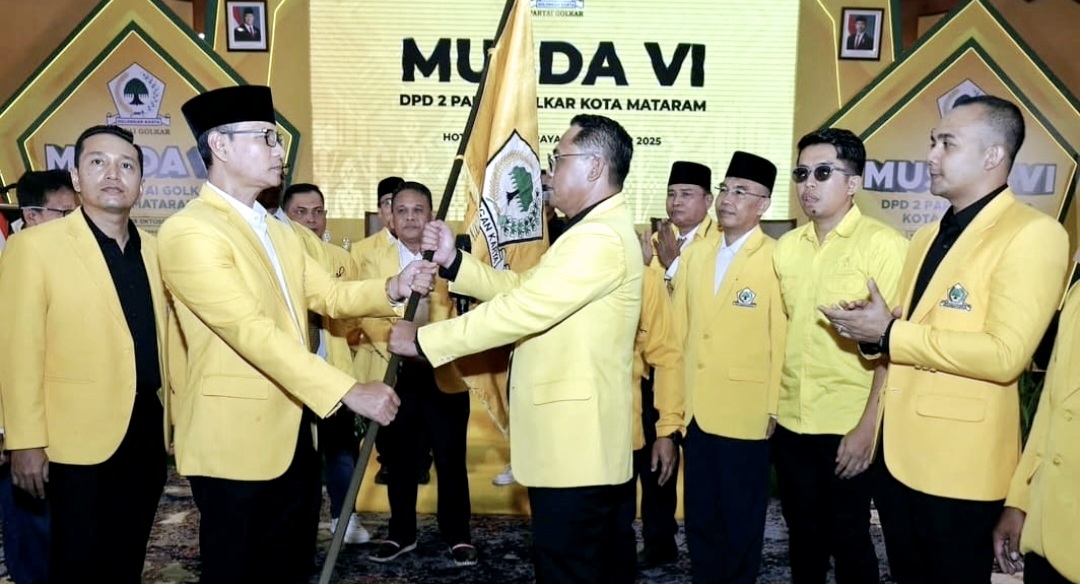 Rino Rinaldi menerima pataka bendera Partai Golkar dari Ketua Golkar NTB Mohan Roliskana usai terpilih aklamasi jadi ketua DPD II Golkar Mataram, Minggu (19/10).