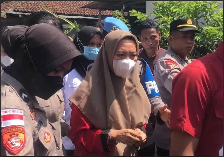 REKONSTRUKSI: Tersangka Brigadir Rizka (pemeran pengganti) dikawal polisi saat menjalani rekonstruksi di rumahnya, Dusun Nyiur Lembang Dalem, Desa Jembatan Gantung, Kabupaten Lombok Barat.