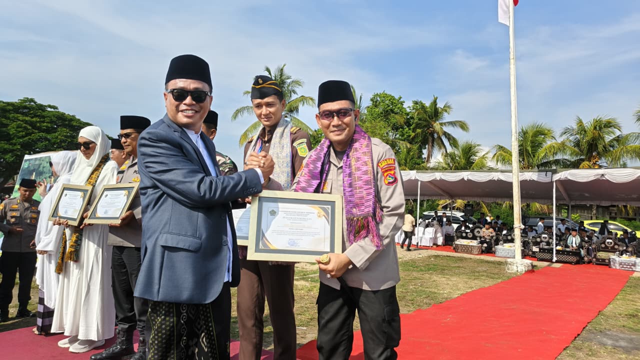 Kapolres Loteng AKBP Eko Yusmiarto menerima penghargaan dari Kanwil Kemenang NTB Zamroni Aziz pada peringatan Hari Santri Nasional, di Lapangan Umum Desa Penujak, Praya Barat, Rabu (22/10)