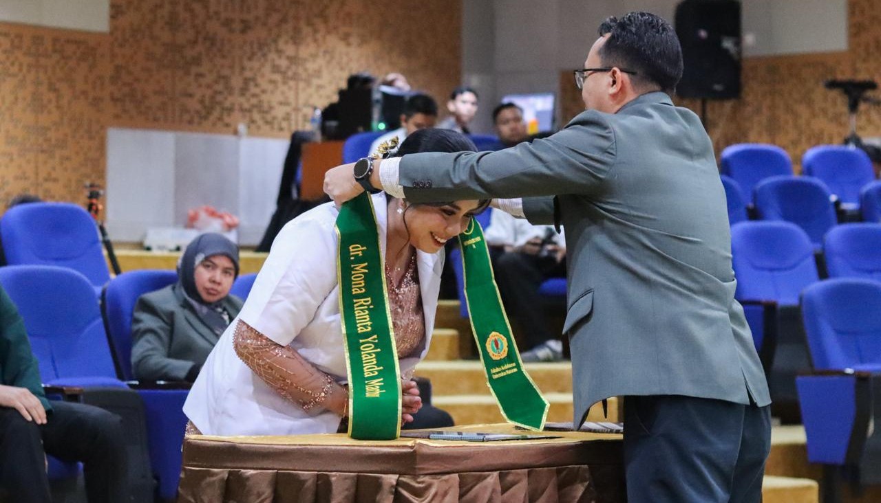 Dekan FKIK Unram Dr dr Arfi Syamsun mengalungkan selempang pada dokter baru dan pengambilan sumpah dokter ke-54 di Aula dr Yunita Sabrina FKIK Unram, Rabu (22/10). FKIK Unram perkuat pemerataan dokter