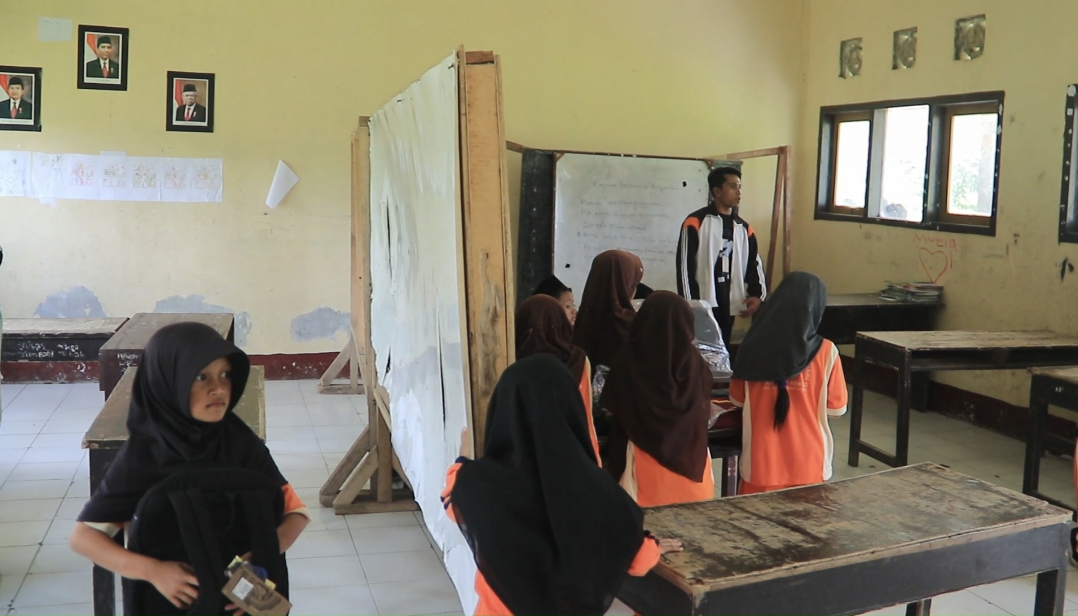 Seorang guru sedang mengajar para murid di dalam kelas, SDN Tambing Kekeq, Desa Aik Berik, Batukliang, Loteng.