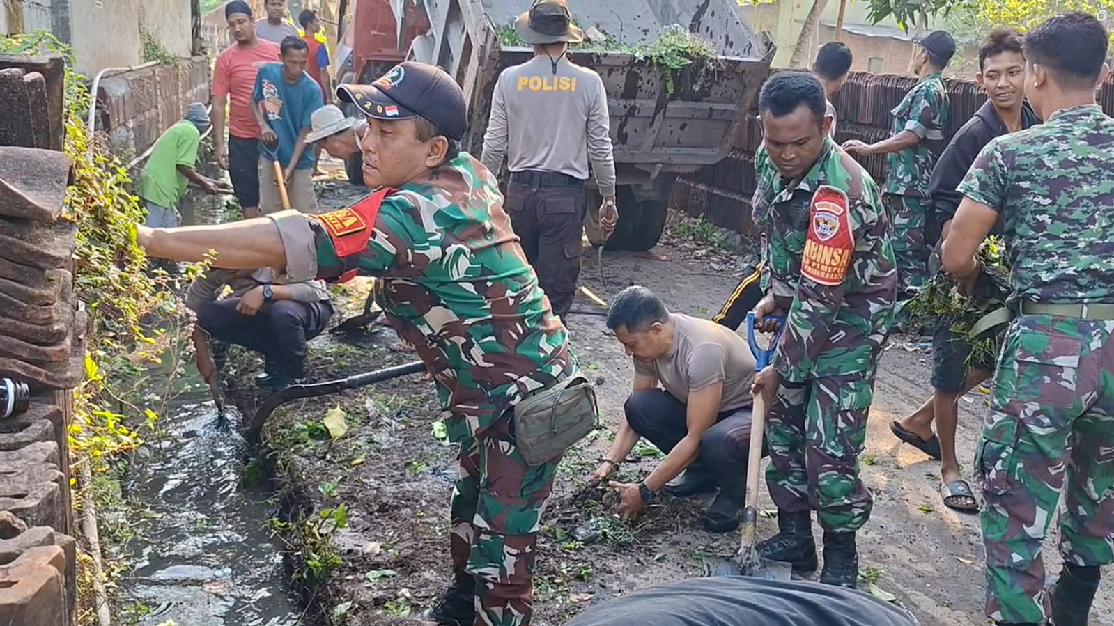 Puluhan warga Dusun Sempoja, Desa Menemeng bersama anggota TNI berjibaku membersihkan saluran air yang berlumpur menjelang musim hujan tiba.