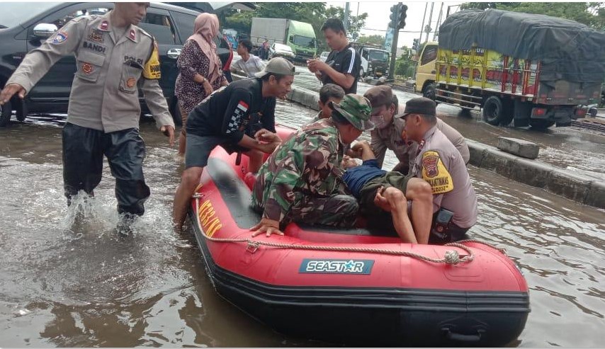 SIAP SIAGA: Personel kepolisian bersama TNI mengevakuasi warga yang sakit menuju RSI Sultan Agung Semarang, Minggu (26/10).