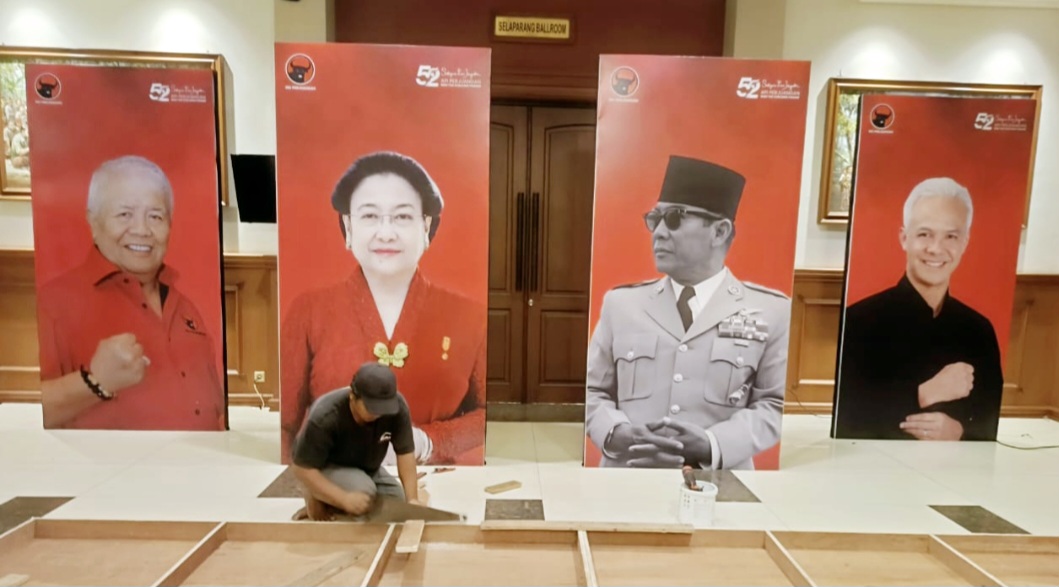 Pekerja sedang menata dekorasi di depan foto Ketua Umum PDIP Megawati Soekarnoputri untuk pelaksanaan Konferda dan Konfercab PDIP NTB di ballroom Hotel Lombok Raya, Mataram, Minggu malam (26/10).
