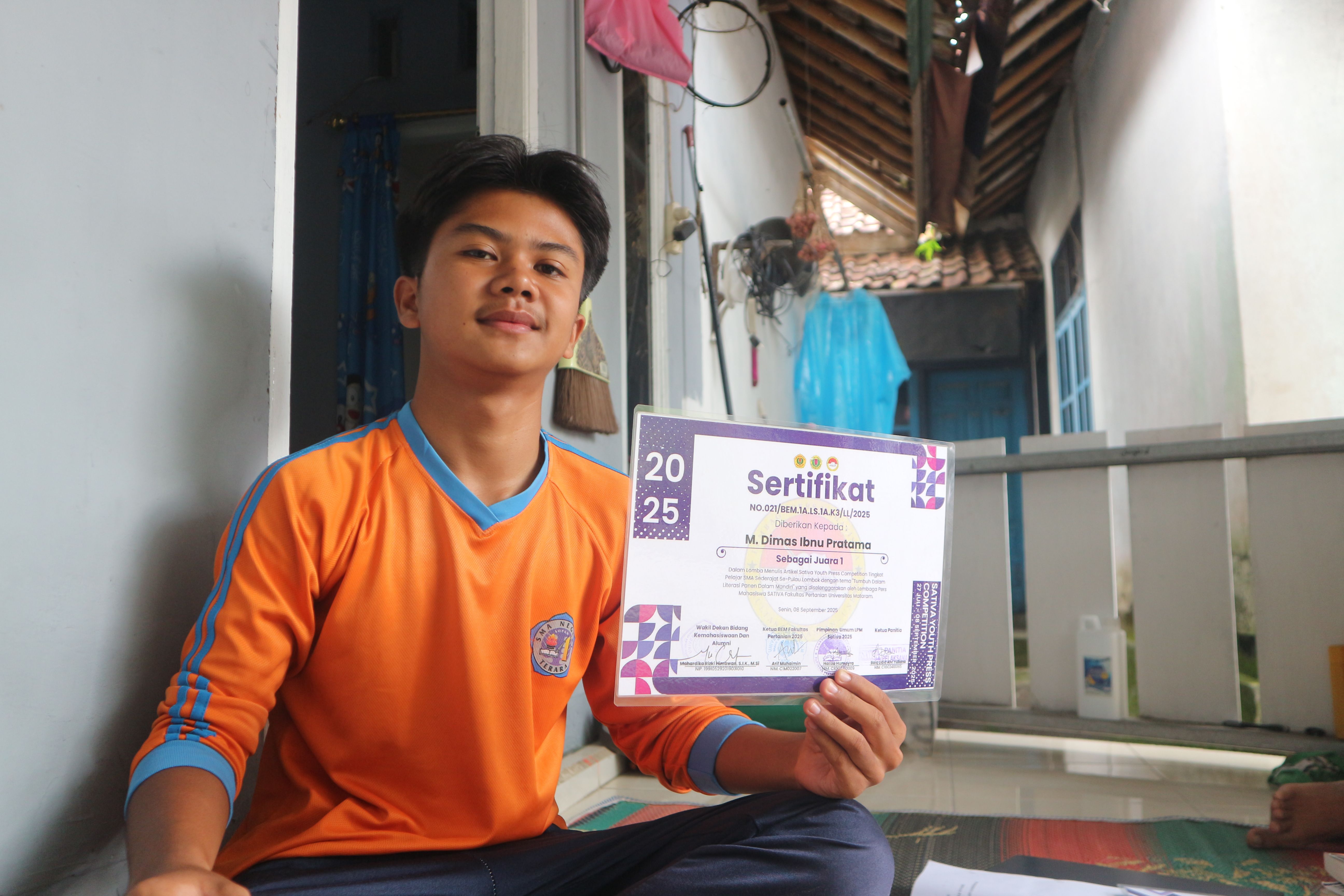 M Dimas Ibnu Pratama saat memperlihatkan salah satu piagam penghargaan lomba menulis yang didapatkan tahun 2025 ini, Minggu (26/10)