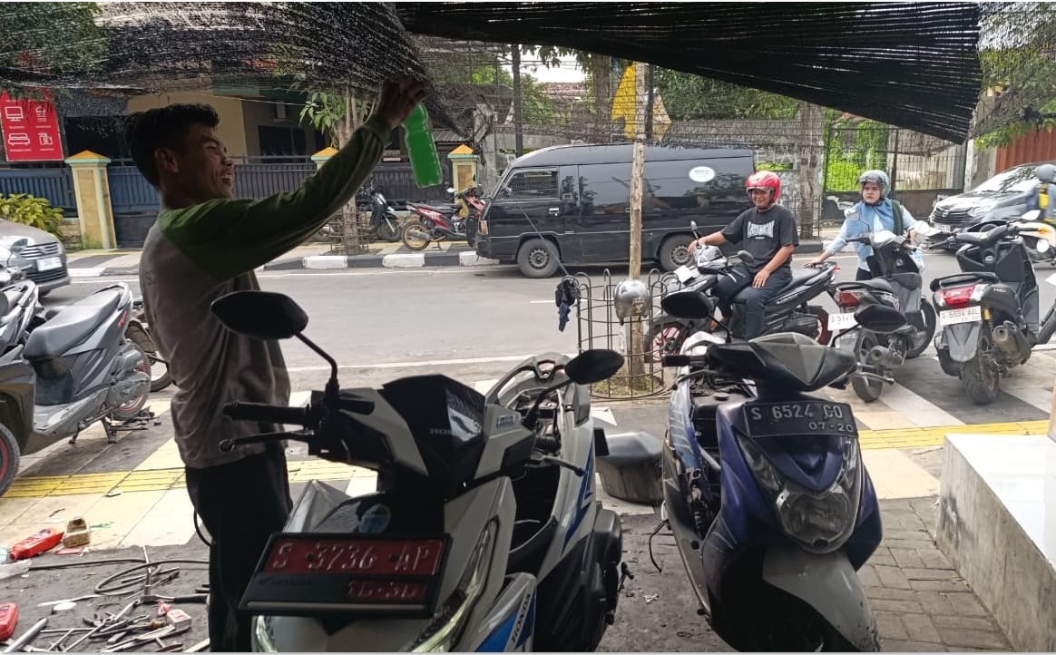 KELUHAN SERUPA: Salah seorang mekanik di bengkel Jalan Basuki Rahmat, Bojonegoro, kebanjiran order Senin (27/10).