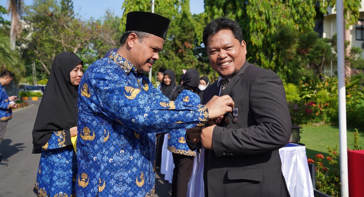 Rektor Unram  Prof. Ir. Bambang Hari Kusumo memasangkan lencana Satyalancana Karya Satya sebagai bentuk penghargaan terhadap loyalitas ASN pada peringatan Sumpah Pemuda ke-97, Selasa (28/10).