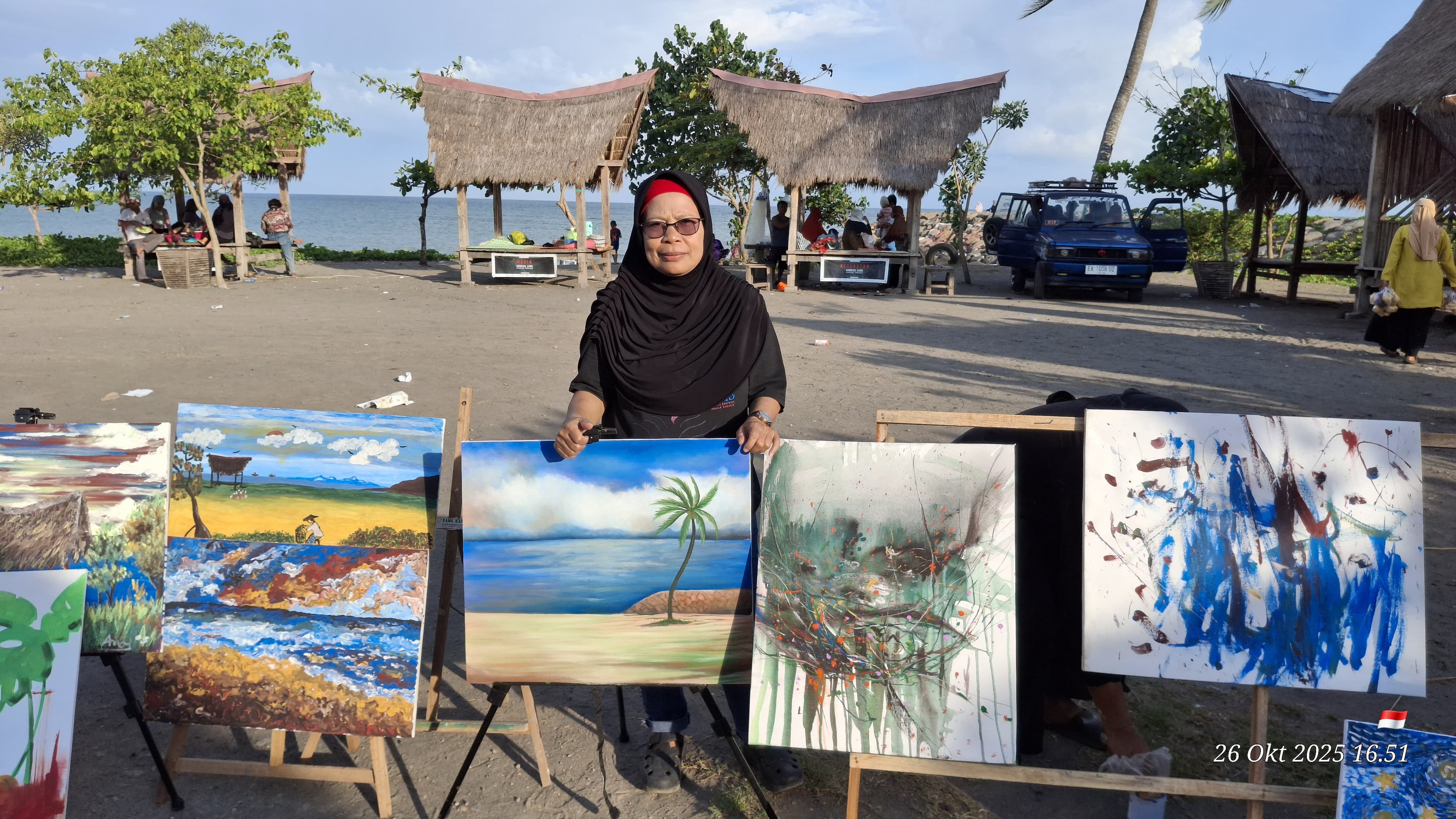 Maimanah salah seorang pelukis senior di Lombok Timur, saat memperlihatkan lukisan hasil Live Painting di pantai Sunrise Land Lombok.