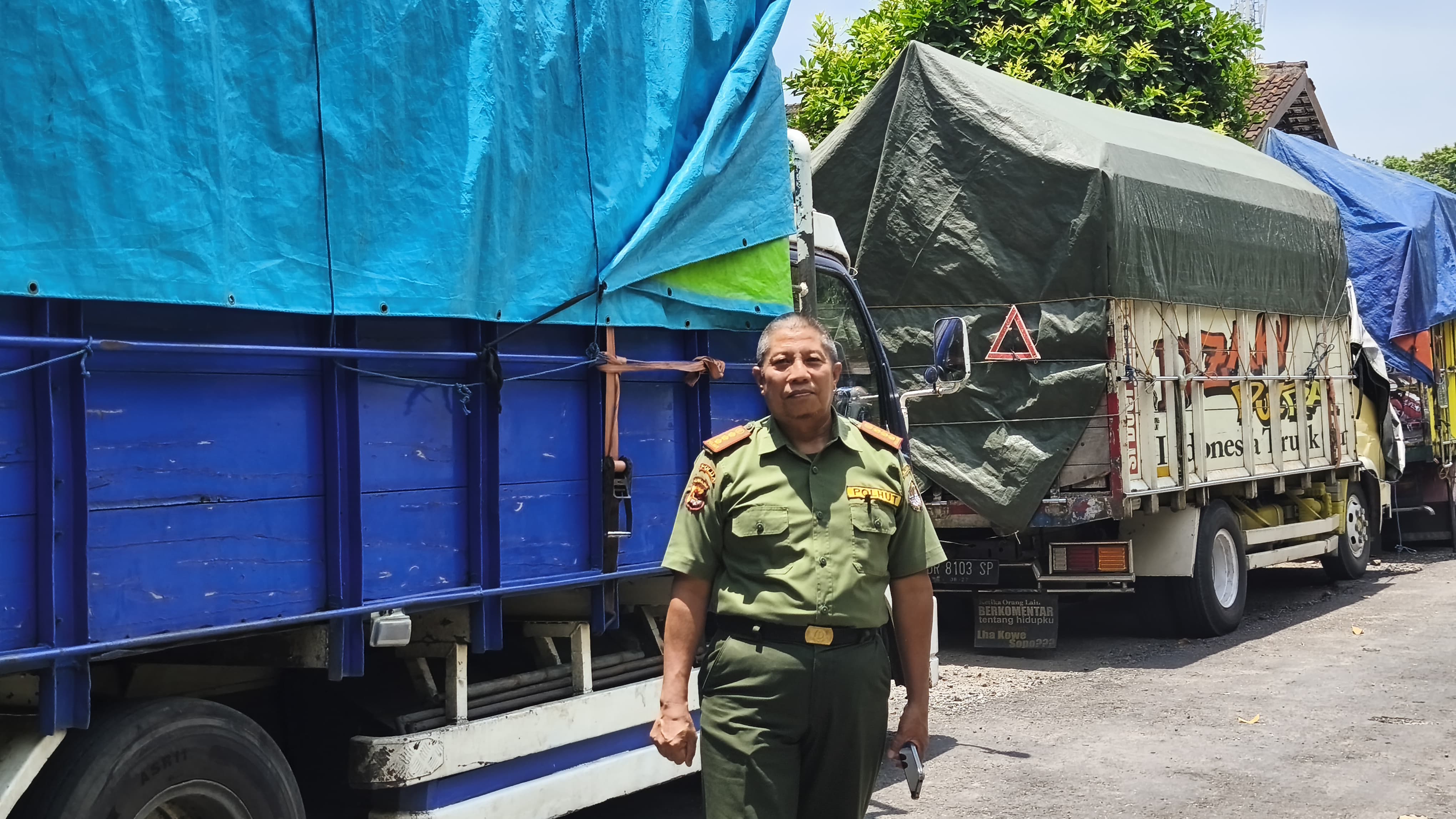 Kepala Bidang Perlindungan dan Konservasi Alam DLHK NTB Mursal berdiri di depan truk pengangkut kayu ilegal yang diamankan di kantor DLHK setempat, Rabu (29/10).