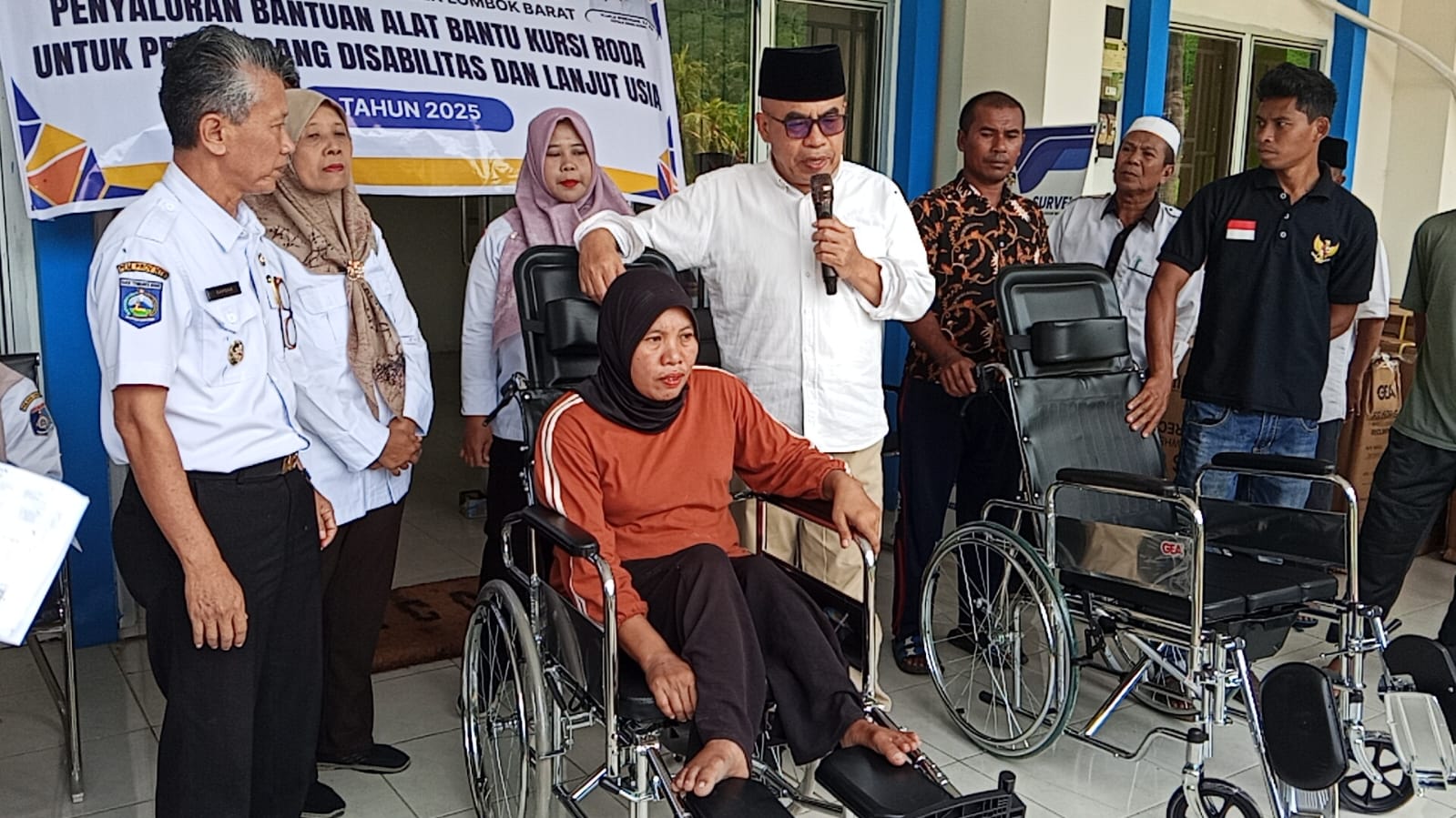 BERI BANTUAN: Kepala Dinas Sosial Lombok Barat Lalu Winengan (pakai peci) bersama Camat Lembar Sapoan (kiri) saat menyalurkan bantuan kursi roda yang kepada penyandang disabilitas dan lansia.