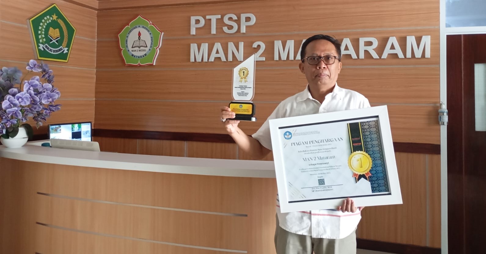 Kepala MAN 2 Mataram H Lalu Syauki menunjukkan piagam penghargaan juara I Pengutamaan Bahasa Negara tingkat NTB di madrasah setempat, pekan lalu. Madrasah ini siap mewakili NTB ke tingkat nasional.
