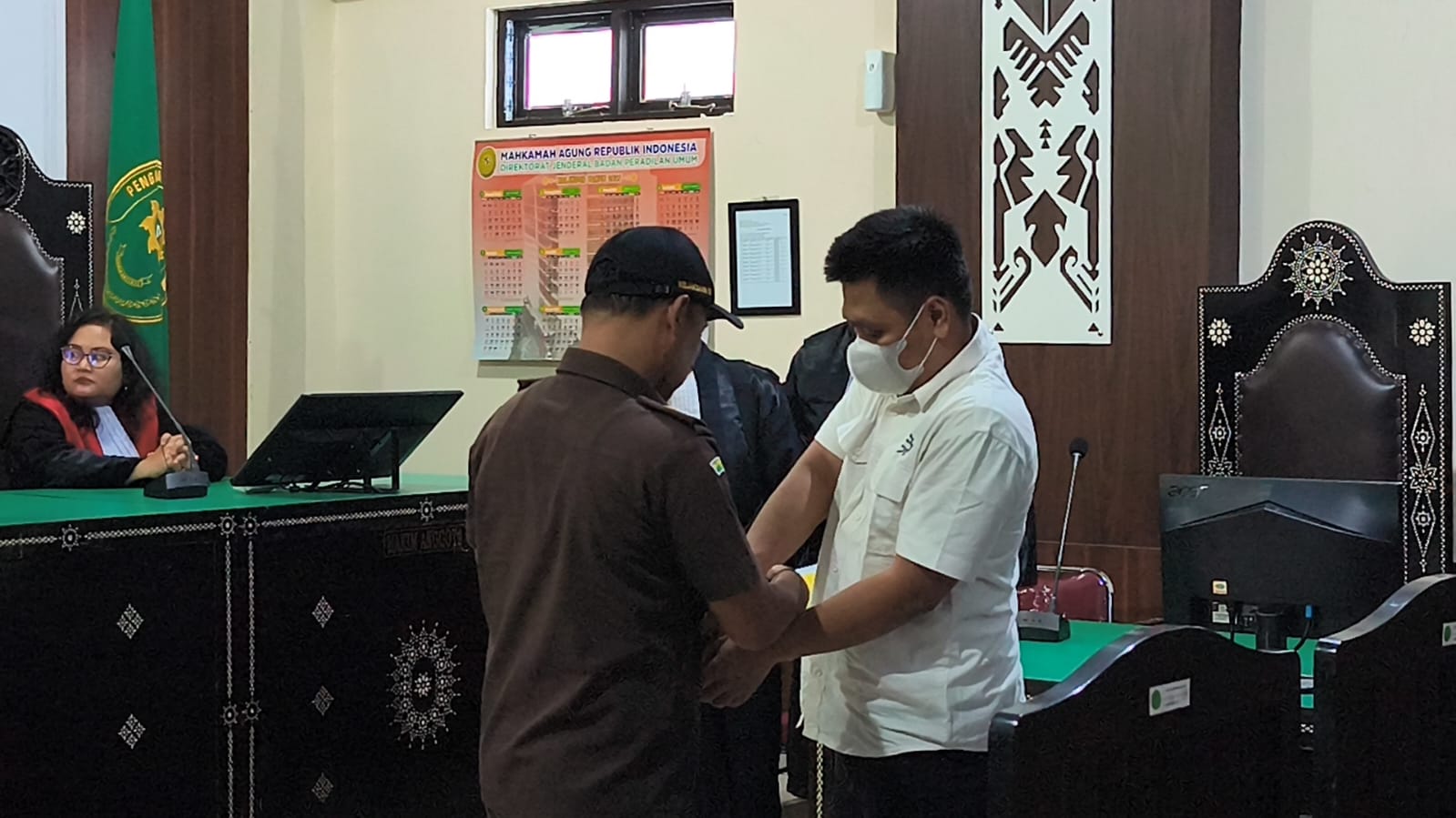 BACAAN EKSEPSI: Pengawal tahanan membuka borgol terdakwa Ipda Gde Aris Chandra Widianto saat hendak mulai sidang di PN Mataram, Senin (3/11).