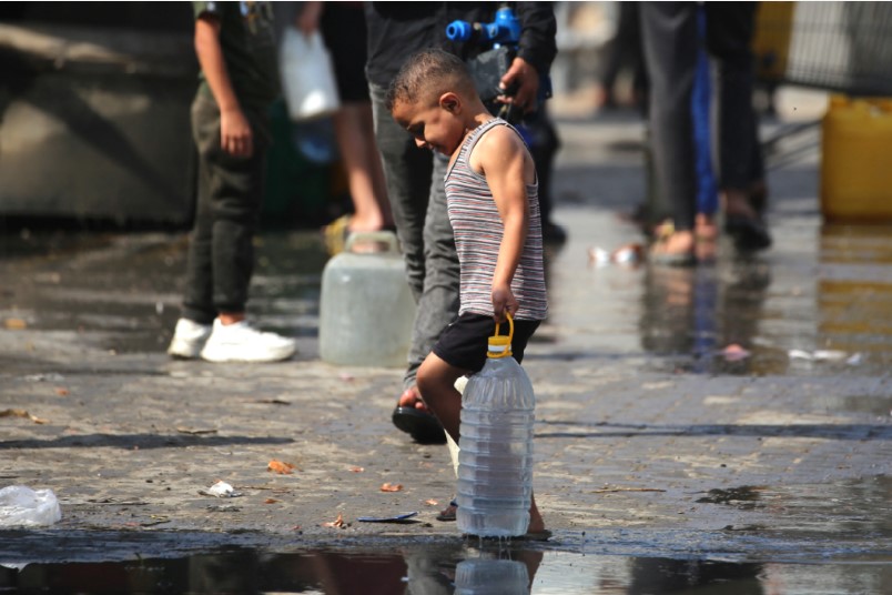 MEMPRIHATINKAN: Seorang anak Palestina dengan pancinya sedang antre untuk menerima minuman.