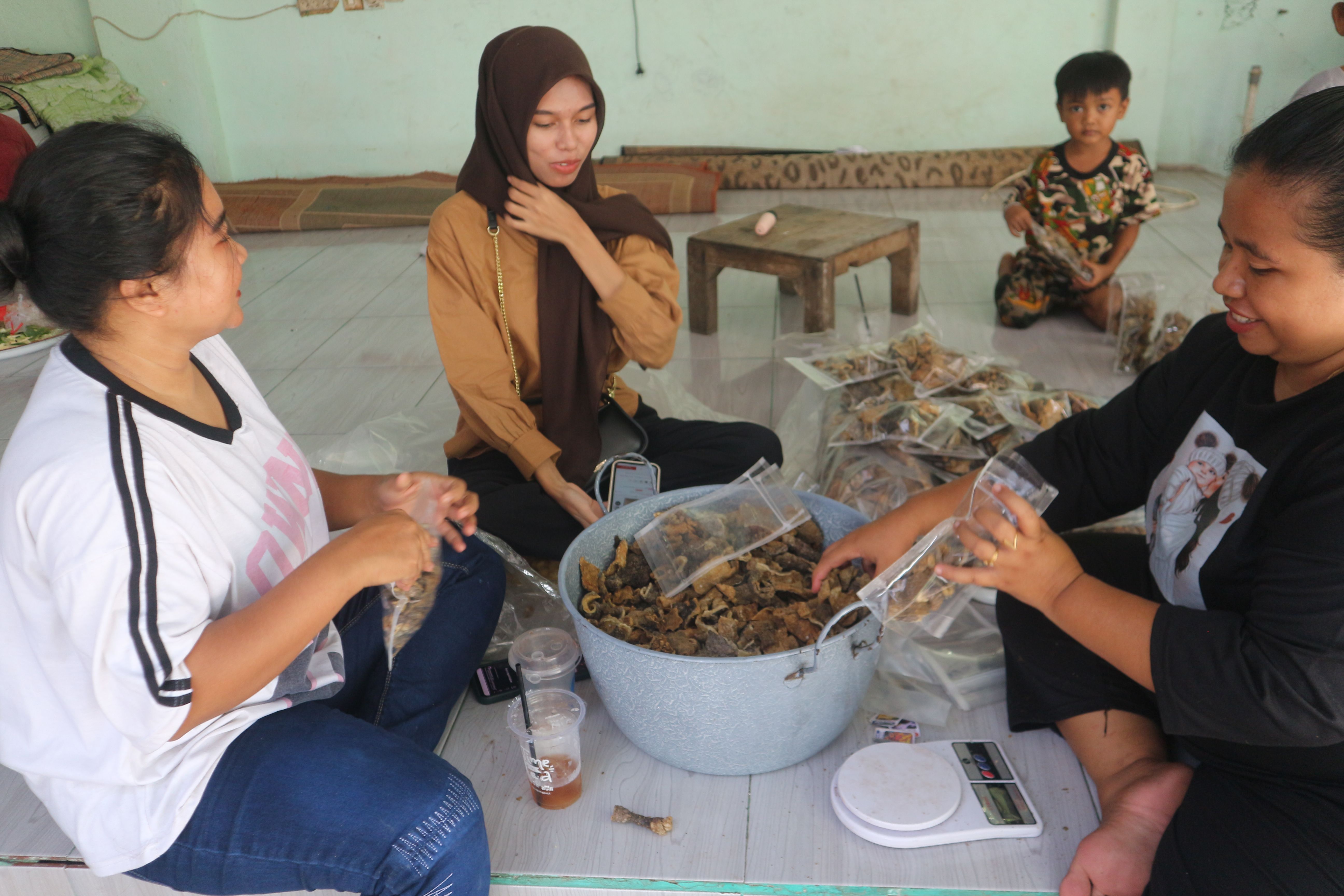 Ibu-ibu di Desa Seruni Mumbul saat membungkus kerupuk kulit ikan tuna.