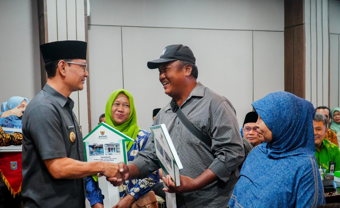 Wali Kota Mataram H. Mohan Roliskana menyalami salah satu penerima bantuan gerobak usaha dalam program Mataram Sejahtera yang digagas Baznas Kota Mataram.