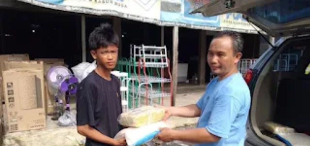 PEDULI: Pengurus Gerakan Pramuka Kwarran Kecamatan Kayangan menyerahkan bingkisan kepada salah satu peserta jambore