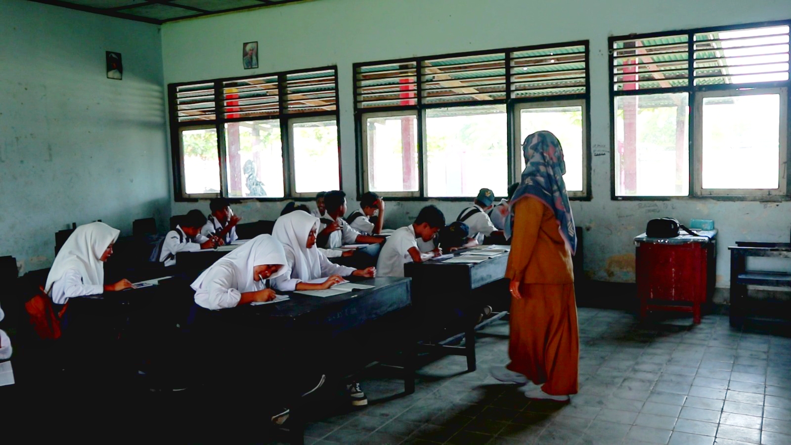 TINGKATKAN KUALITAS: Seorang guru sedang mengajar para muridnya di dalam kelas, beberapa waktu lalu.