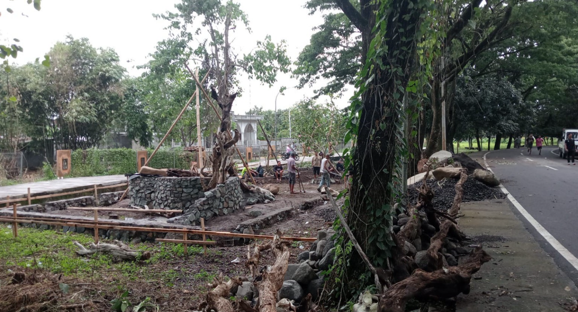 Penataan lansekap di sekitar aviary menggunakan material alami seperti batu besar dan akar pohon untuk menjaga estetika hijau khas RTH Pagutan.
