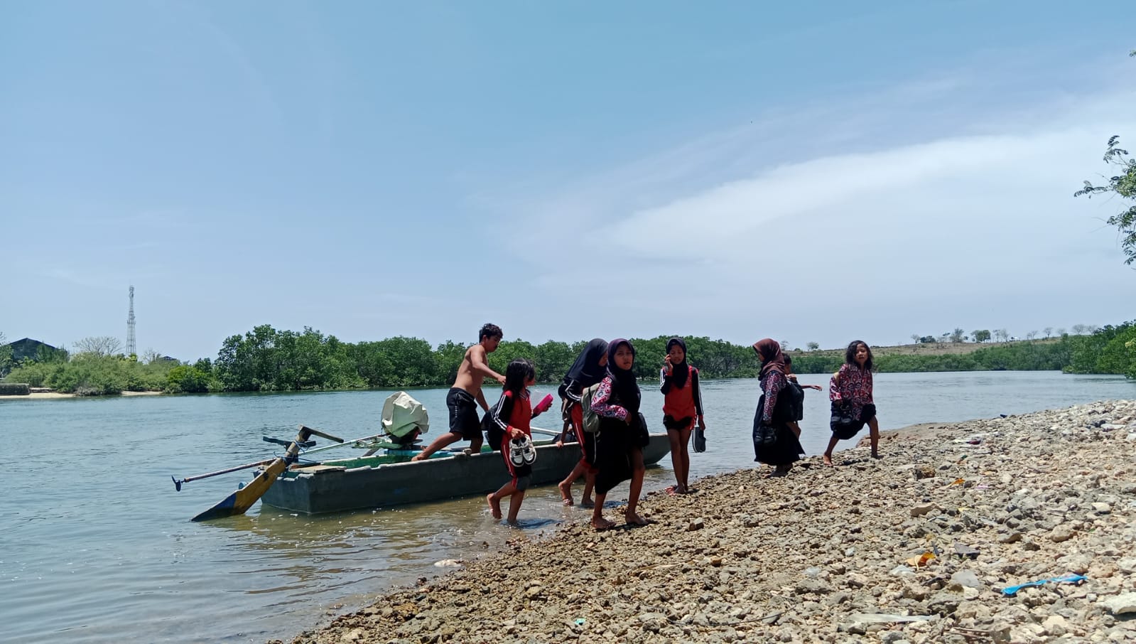 Anak-anak di Dusun Penyonggok, Desa Seriwe, Kecamatan Jerowaru pulang sekolah dengan naik perahu untuk menyeberangi muara sepanjang sekitar 100 meter lebih.