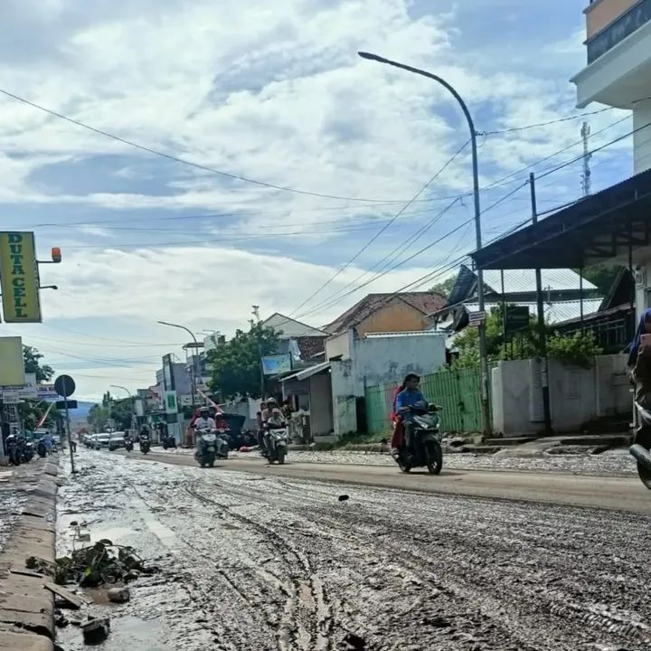 Kondisi jalan raya di Kota Bima yang dipenuhi lumpur akibat banjir, Minggu (9/11).