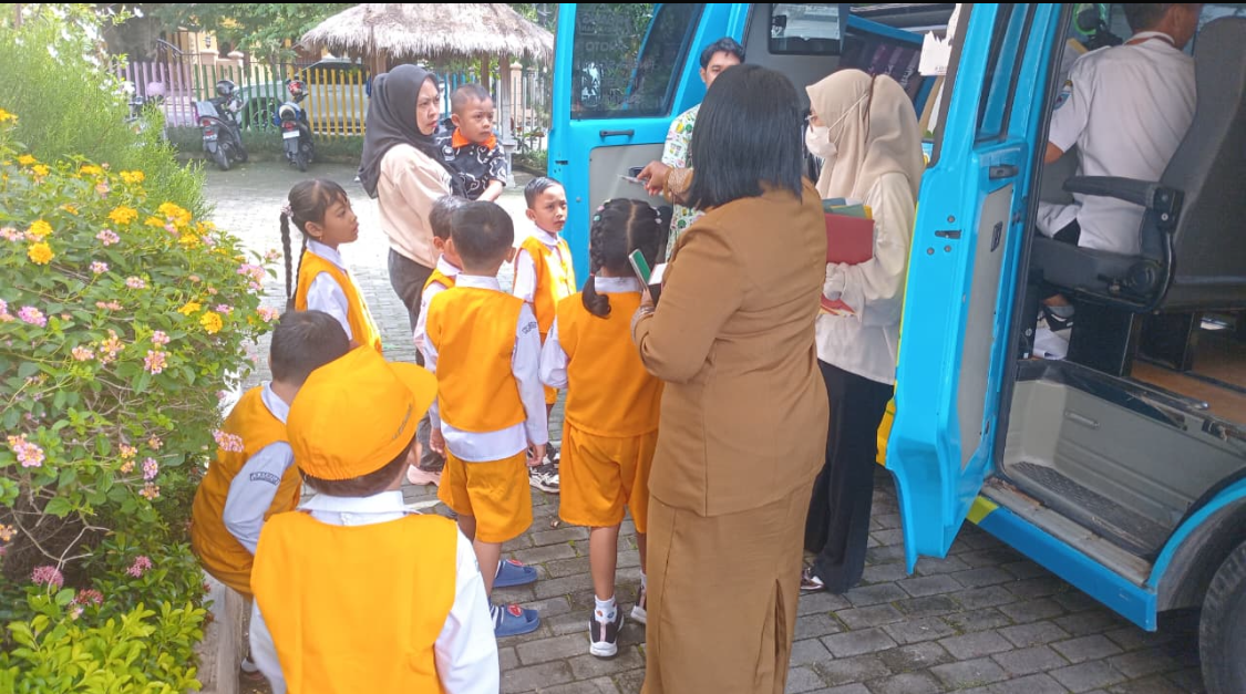Petugas Dukcapil memberikan arahan kepada siswa TK Kemala Bhayangkari sebelum masuk ke mobil layanan untuk proses perekaman data KIA.