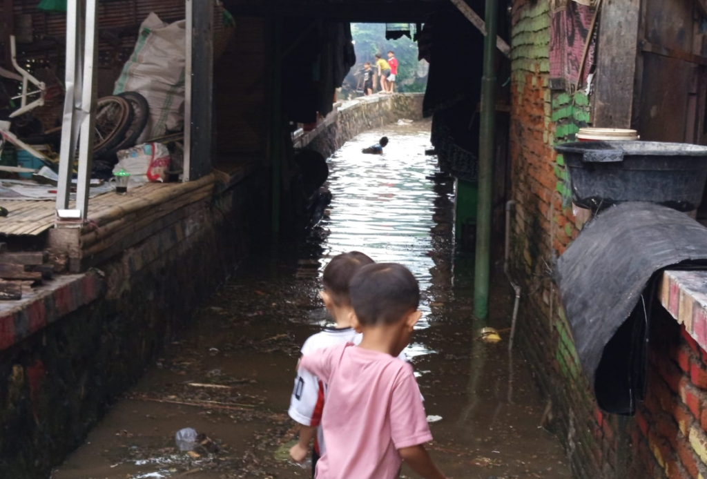 TERGENANG: Dua balita yang bermain di tengah genangan air wilayah Kekalik Jaya, Rabu (12/11).